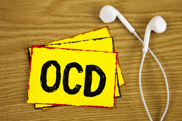 Word writing text Ocd. Business concept for Obsessive Compulsive Disorder Psychological Illness Medical Condition written on Yellow Sticky Note Paper on wooden background Handsfree next to it. - Photo, Image