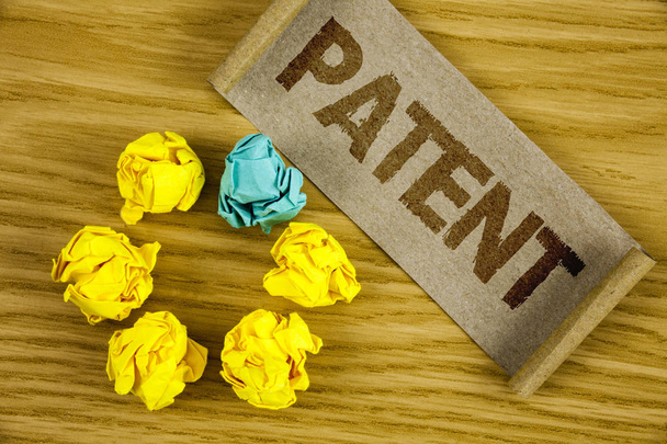Text sign showing Patent. Conceptual photo License that gives rights for using selling making a product written on Folded Cardboard Paper piece on wooden background Crumpled Paper Balls. - Photo, Image