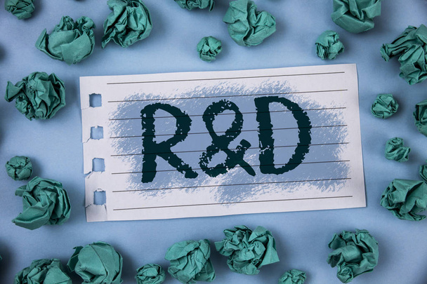 Szöveg jel bemutatás R D. fogalmi fénykép kutatás és fejlesztés tudományos vizsgálatok újítások írt a Jegyzettömb papír belül zöld papír golyó sima kék háttér. - Fotó, kép