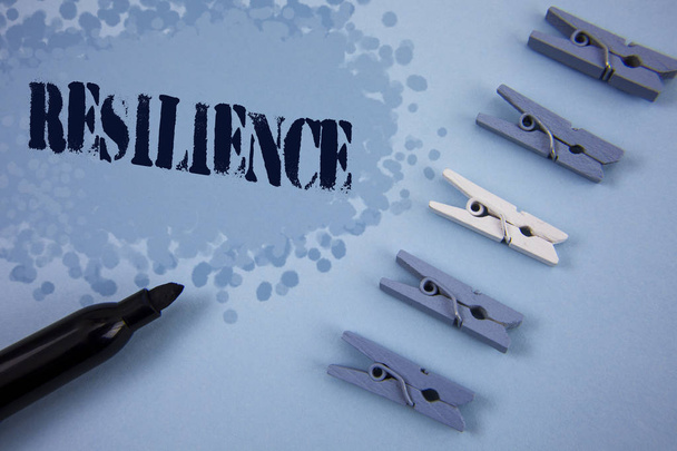 Writing note showing  Resilience. Business photo showcasing Capacity to recover quickly from difficulties Persistence written on Painted background wooden Clips and Marker next to it. - Photo, Image