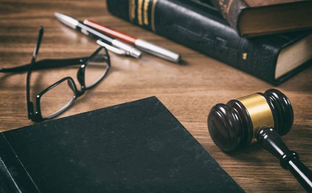 Law or auction gavel and a book, wooden office desk background. Closeup view, space for text - Fotoğraf, Görsel