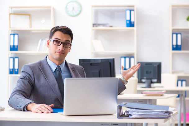 Hombre de negocios guapo empleado sentado en su escritorio en la oficina - Foto, Imagen