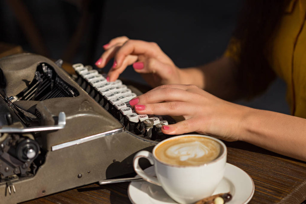 Женские пальцы печатают на серой ретро-машинке с белыми клавишами. Мелкая глубина резкости. Горизонтальная композиция
. - Фото, изображение