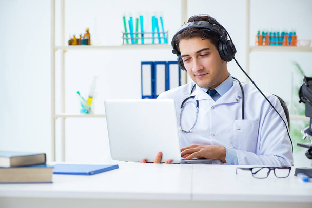 Mužský lékař naslouchá pacientovi během telemedicínského sezení - Fotografie, Obrázek