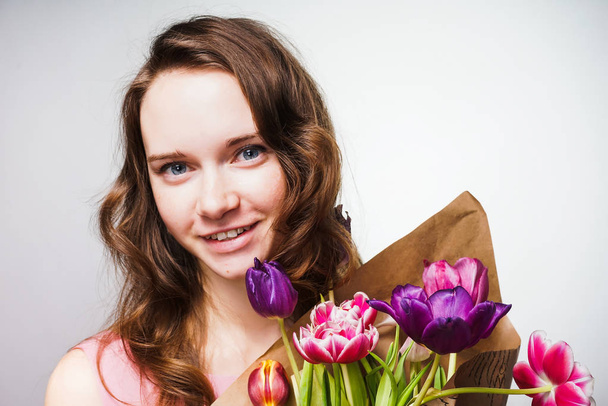 beautiful happy girl holding a big bouquet of fragrant flowers, celebrating Mother's Day - Foto, afbeelding