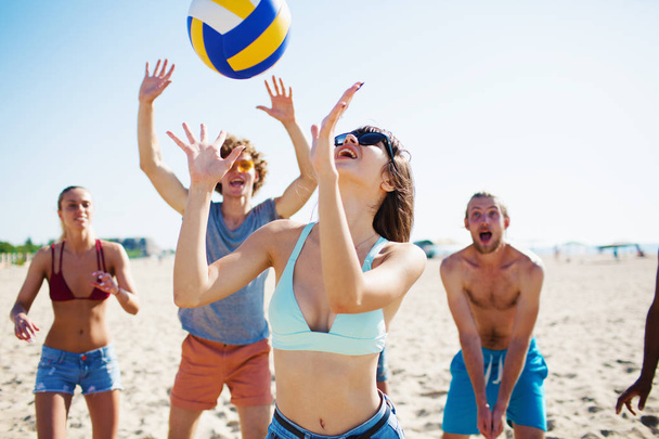 Groupe d'amis jouant au beach volley à la plage
 - Photo, image