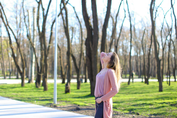Nuori nainen hengittää raitista ilmaa puistossa ja rentouttava
. - Valokuva, kuva