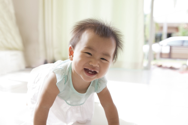 アジアの赤ちゃんの顔 10 ヶ月熟成のリビング ルームでクロール - 写真・画像