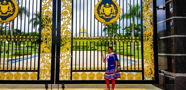 nainen edessä portin istana negara, Malaysia
 - Valokuva, kuva