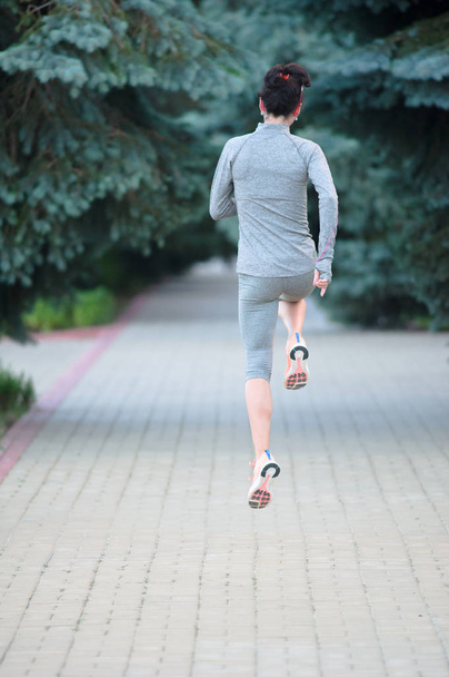 pernas de corredor na visão traseira em um parque da cidade. Visão traseira mulher esporte r
 - Foto, Imagem