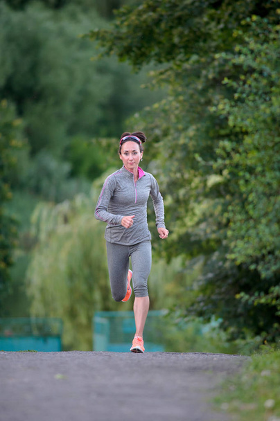 fitness sports female racer running on park - Photo, image