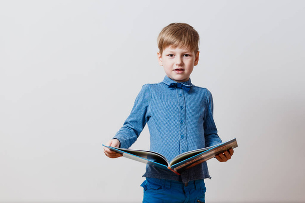 boy in a blue shirt with a big book in his hands - Valokuva, kuva
