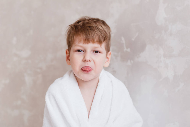boy in white towel showing tongue - Zdjęcie, obraz