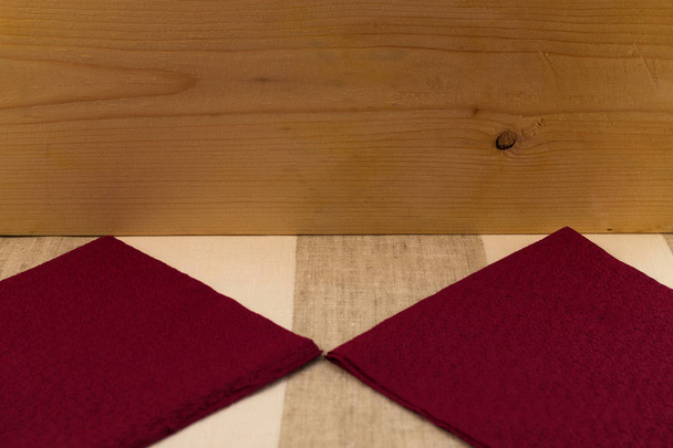 Fondo (textura), una superficie de madera de un tablero, un paño rayado de tela de lino, servilletas de papel bardo de la forma cuadrada con un patrón pequeño
. - Foto, Imagen