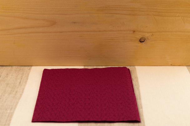 Tło - powierzchni drewnianych deskach w góry, serwetka w kształcie kwadratu bard, lniane tkaniny w paski. - Zdjęcie, obraz