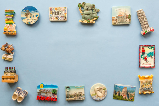 различные сувенирные магниты из нескольких стран мира расположены на синем фоне
 - Фото, изображение