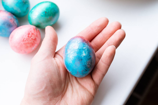 Holding a colorful easter egg - 写真・画像