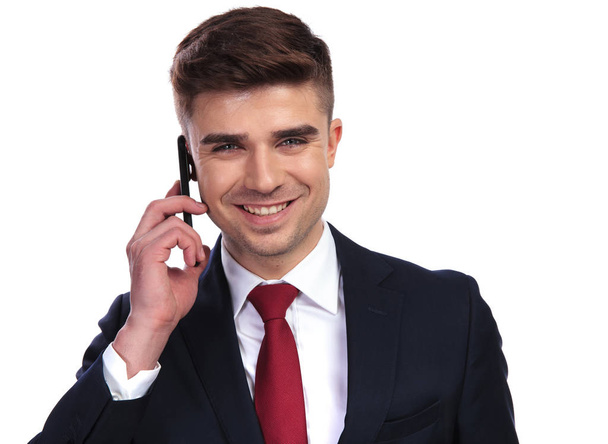 Красивый смеющийся бизнесмен разговаривает по телефону
 - Фото, изображение