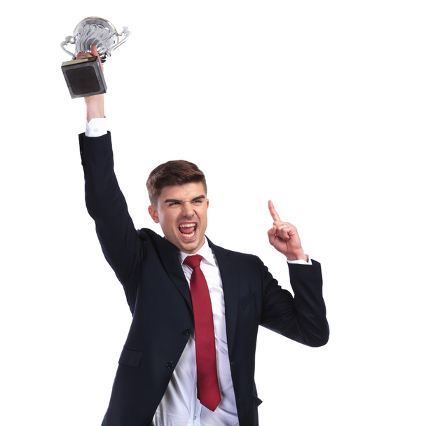 kampioen zakenman holding trofee en vinger omhoog - Foto, afbeelding