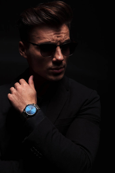 fashion man shows his watch and looks to side - Zdjęcie, obraz