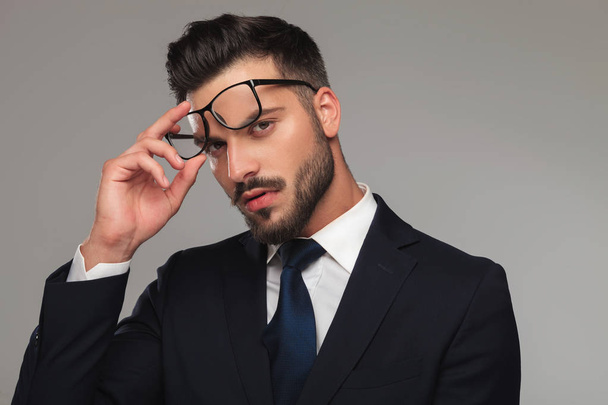 Porträt eines sinnlichen Geschäftsmannes, der die Brille abnimmt - Foto, Bild
