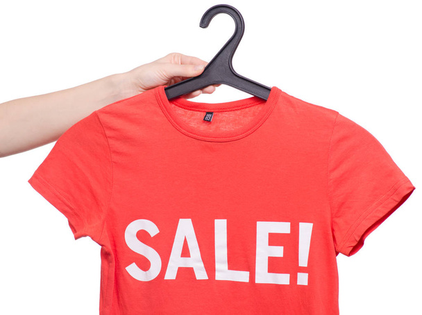 T-shirt with an inscription sale on a hanger in hand shop buy discount - Foto, afbeelding