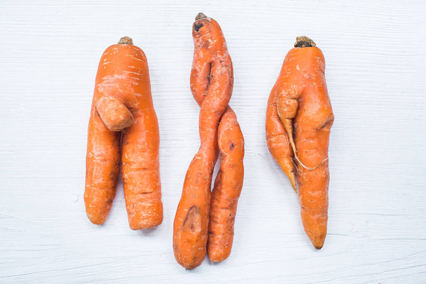 Забавная форма моркови на белом фоне доски
 - Фото, изображение