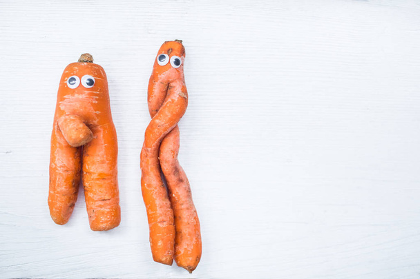 Забавная форма моркови с глазами на белом фоне доски. Копирование пространства
 - Фото, изображение