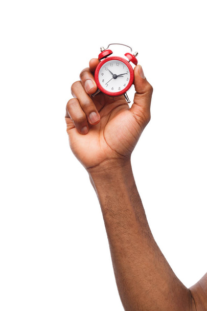 Mano masculina negra sosteniendo reloj despertador rojo
 - Foto, Imagen