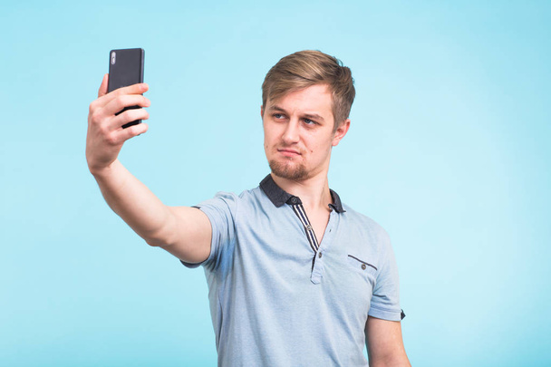 Zabawny człowiek fotografowanie siebie na smartfonie - Zdjęcie, obraz