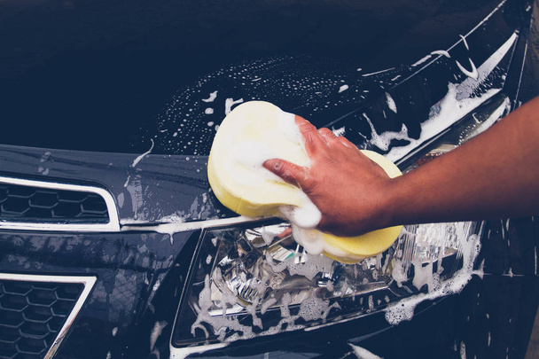 Les hommes utilisent une éponge jaune pour laver la voiture
 - Photo, image