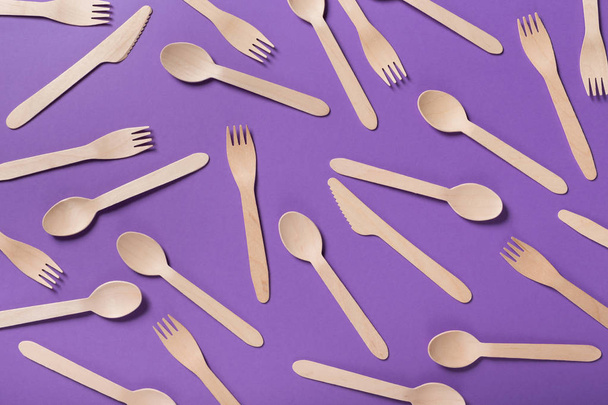 Many wooden spoons on purple background, top view - Photo, Image