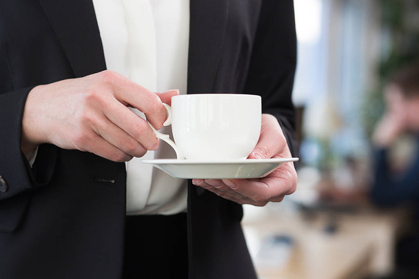 Beautiful businesswoman drinking coffee in office - Photo, image