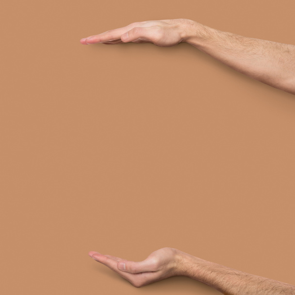 Mężczyzna ręce pomiarowych niewidoczny element o beżowym tle - Zdjęcie, obraz