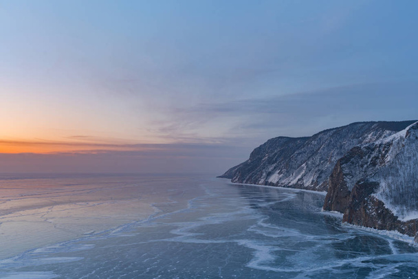 Baikal frozen water lake with sunset skyline, winter season natural landscape background - Foto, afbeelding