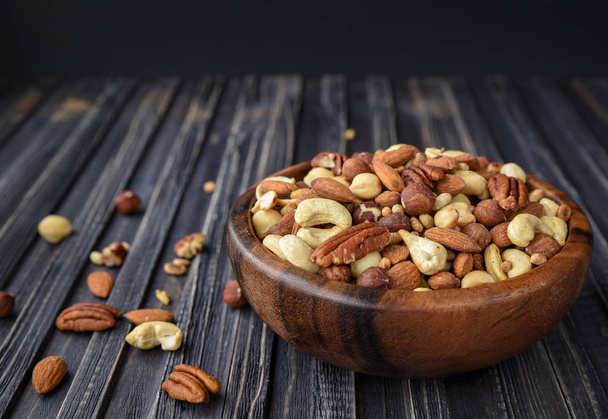 Nuts mix in a wooden plate - Photo, Image