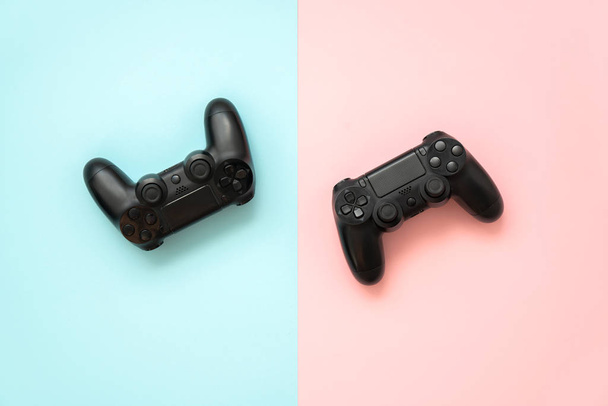 Twee spel joystick van de set-top box op een blauwe en roze achtergrond. Het concept van games voor jongens en meisjes. - Foto, afbeelding