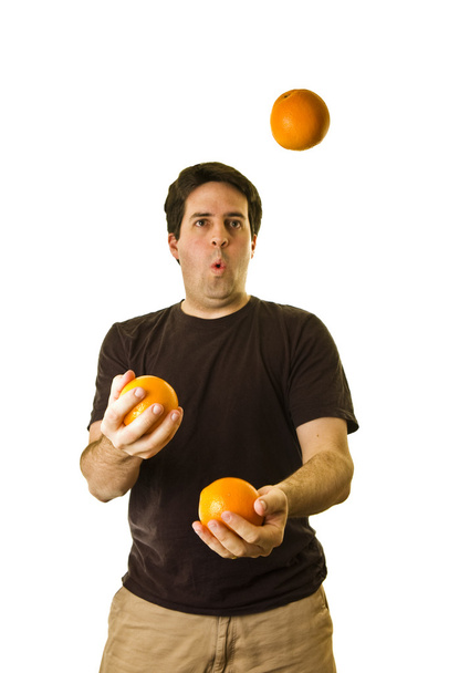 ένας άνθρωπος κάνει ταχυδακτυλουργίες τρία πορτοκάλια - Φωτογραφία, εικόνα