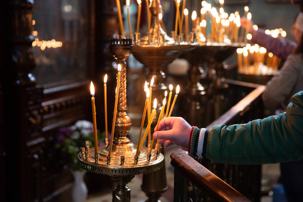 Mann zündet Kerzen in einer Kirche an - Foto, Bild