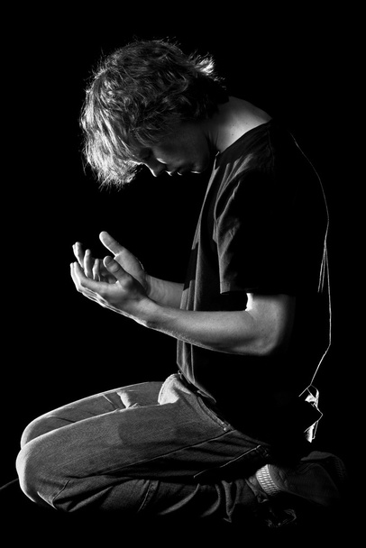 jonge man neerkijkt in handen - Foto, afbeelding