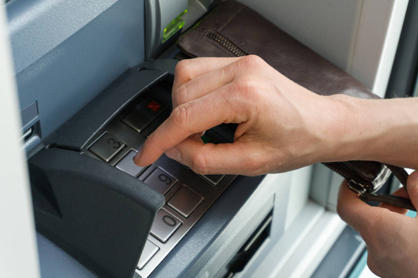 mão feminina inserindo um código PIN seguro em um ponto de caixa ou ATM de perto e em detalhes
 - Foto, Imagem