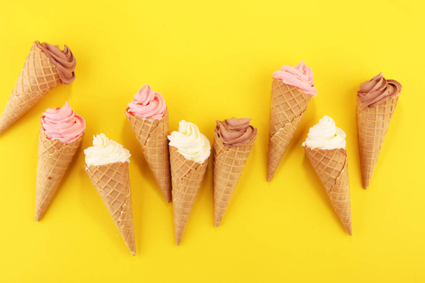 Vanilla frozen yogurt or soft ice cream in waffle cone. - Foto, afbeelding