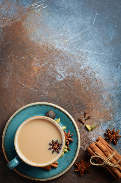 Indian masala chai tea. Spiced tea with milk on dark rusty background. Top view, flat lay, copy space. - Foto, imagen