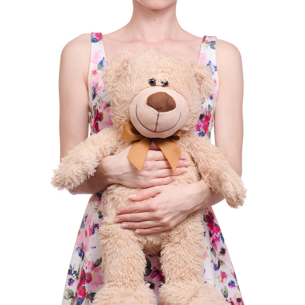 Woman in a dress floral print in the hands of a teddy bear - Φωτογραφία, εικόνα