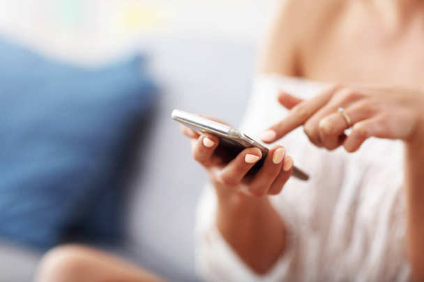 Happy woman relaxing at home with smartphone - Photo, Image