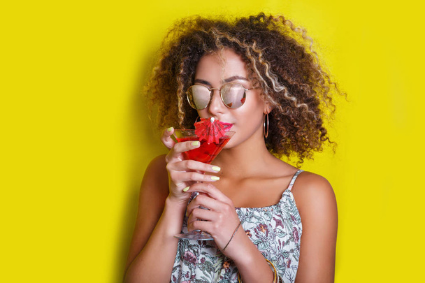 Beautiful afro american woman with pink cocktail at a party - Фото, зображення