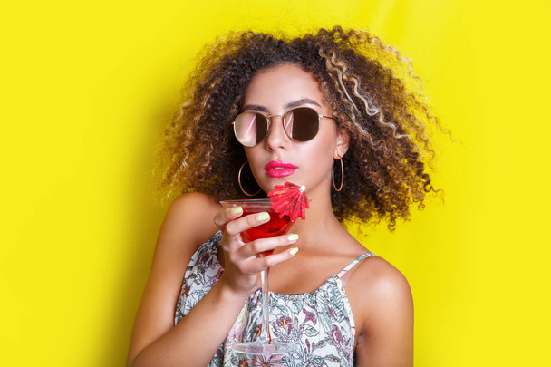 Beautiful afro american woman with pink cocktail at a party in summer. - Fotó, kép