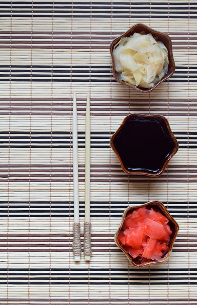 Pickled ginger slices and wooden chopsticks. Ingredient for sushi. Healthy food. Traditional Japanese condiment. - Fotó, kép