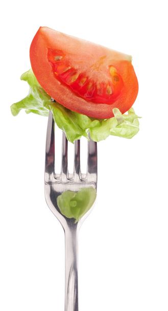 Slice of tomato on the fork isolated on white - Photo, image