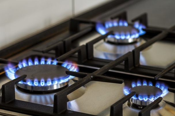 Erdgas, das im Dunkeln auf einem Küchengasherd brennt. Panel aus - Foto, Bild